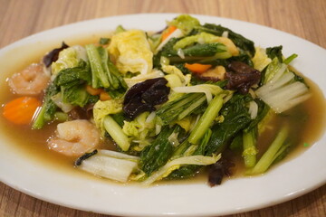 Capcay food containing mustard greens, mushrooms, carrots and other healthy foods at a restaurant