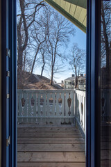 Fototapeta premium Scenic Wooden Balcony Overlooking Residential Neighborhood Under Clear Blue Sky