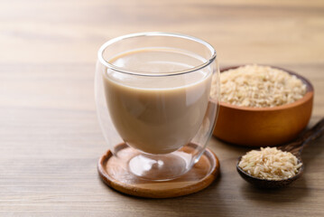 Organic rice milk in cup glass on wooden background, Alternative milk made from plant