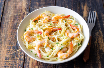 Linguine pasta in creamy garlic sauce with shrimps. Italian food.