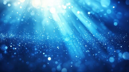 Blue glitter bokeh background with light rays. Ideal for festive designs, adding sparkle and magic to your projects.