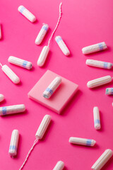 Many menstrual hygiene tampons from above on pink background. Soft cotton absorbent menstrual tampons for women during menstruation. Feminine hygiene. 