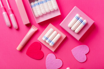 Many menstrual hygiene tampons from above on pink background in beautiful composition. Soft cotton absorbent menstrual tampons for women during menstruation. Feminine hygiene. 