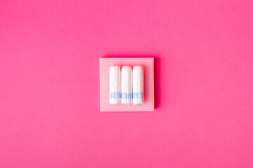 Menstrual hygiene tampons from above on pink background in beautiful composition. Soft cotton absorbent menstrual tampons for women during menstruation. Feminine hygiene. 