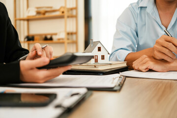 Businesswoman embraces client after successful property negotiation.