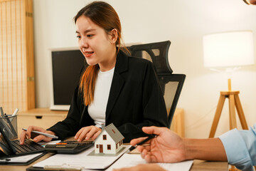 Businesswoman embraces client after successful property negotiation.