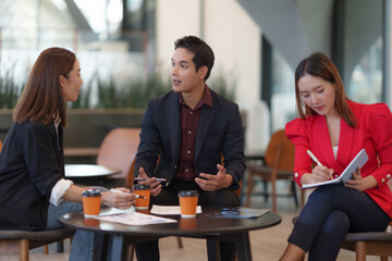 Business team discussing strategy during meeting in office lobby