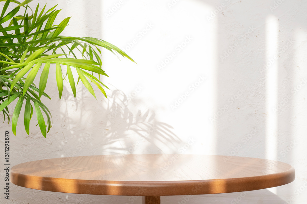 Wall mural close-up of empty clean round table with green palm leaves and window sun light shadows on abstract 