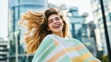 Smiling young woman with flowing hair, enjoying a sunny day in the city.