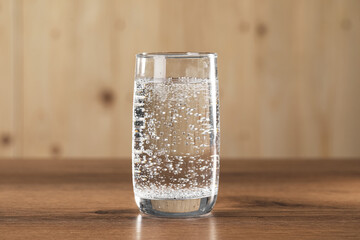 Refreshing soda water in glass on wooden table, closeup