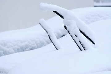 Close-up of windshield wipers of snow covered cars in winter. Seen in Germany in February.
