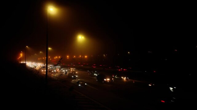 Misty timelapse at night of freeway, highway with traffic and halation