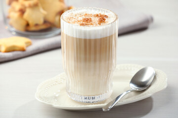 Tasty latte macchiato in glass on white table, closeup. Coffee drink