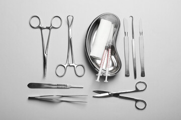 Different surgical instruments on light grey background, flat lay