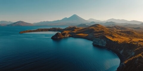 Fototapeta premium Serene coastal landscape with mountains under bright blue sky