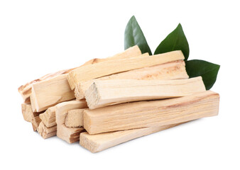 Pile of palo santo sticks and green leaves on white background