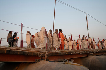 Prayagraj,India-27 pJanuary 2025 Newly made female saint Naga sadhu going to her tent from Pipa Bridge at the Kumbh Mela in Prayagraj or Allahabad Uttar Pradesh India