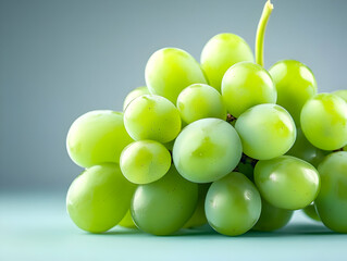 A close-up view of fresh green grapes, showcasing their smooth texture and vibrant color against a soft, neutral background.