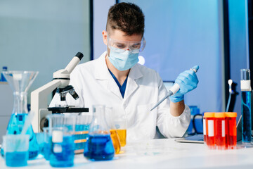 Fototapeta premium Scientist mixing chemical liquids in the chemistry lab. Researcher working in the laboratory