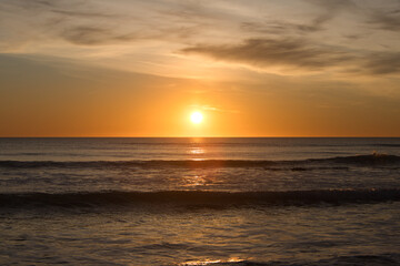 The sun reflecting on the sea in the golden hour in the atlantic ocean in Cadiz, Spain. Reflection of golden sunlight on the water. Sunset view of the sea with bright sunlight.