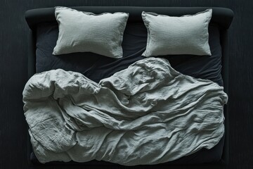 Top view of a bed with gray linen bedding. Ideal for websites selling bedding, home d&eacute;cor, or promoting sleep.