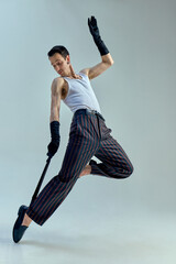 Energetic leap in fluid motion, performer twisting mid-air with microphone as rhythmic extension of...