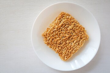 Instant noodle in white plate, uncooked instant noodles on white background