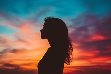 Silhouette of Woman Against Colorful Sunset Sky at Dusk