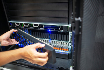 Technician Handling Data Storage Device in Server Room Setup