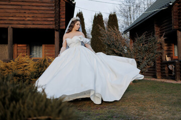 A woman in a white dress is walking in a yard. The dress is long and flowing, and she is wearing a...