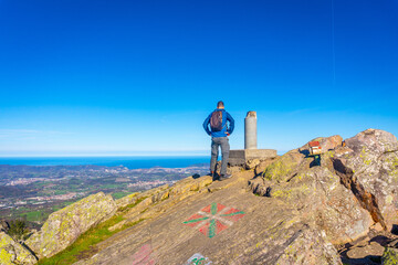 Obraz premium A male hiker on the top of Mount Adarra in Urnieta. Gipuzkoa, Basque Country