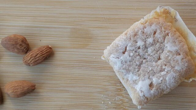 Close-up of almonds, glazed piece of cake and butter. Traditional from Spain during Christmas, Marquesitas Panning view.