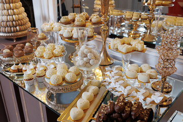 A table full of desserts, including cupcakes and macaroons, is set up for a party