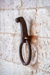 A rusted metal ring is hanging from a wall in Gubbio Italy Umbria