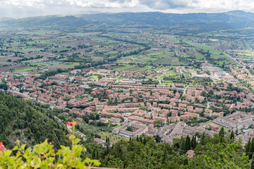 Obraz premium A large field with a few houses in the distance in Gubbio Viewpoint Italy Umbria