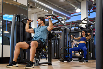 Focused individuals exercising on gym machines