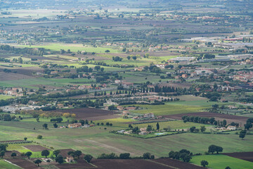 A large field with a few houses in the distance in Gubbio Viewpoint Italy Umbria