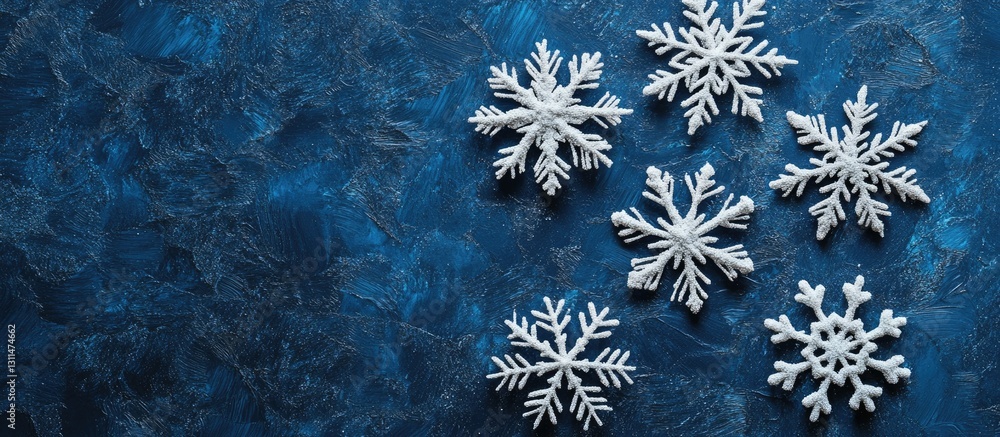 Poster white snowflake decorations arranged artfully on a textured deep blue background showcasing contrast