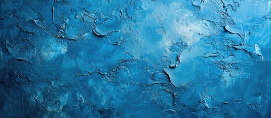 Textured blue wall background with abstract patterns and tonal variations in deep and light blue, ideal for design projects and copyspace.