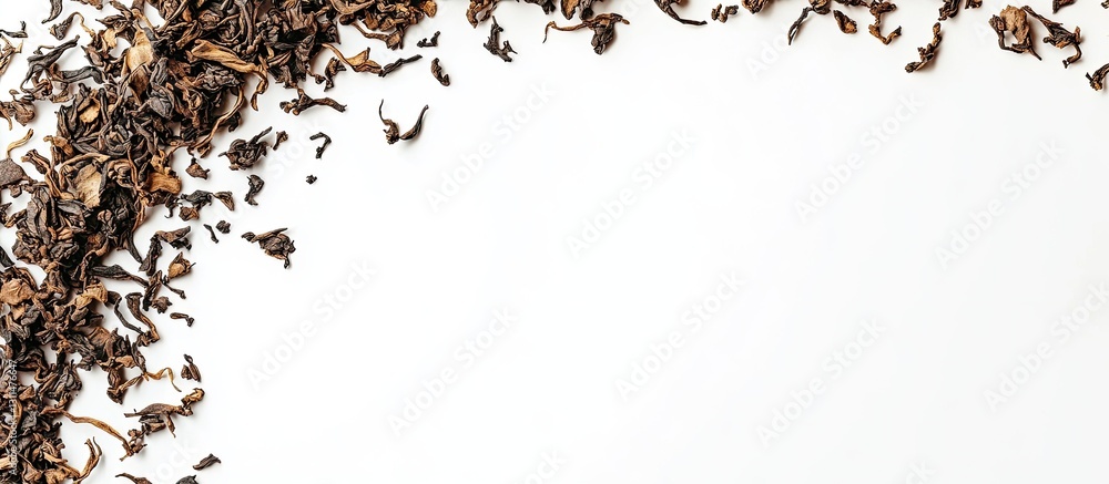 Aufkleber Dried tea leaves arranged in a corner on a clean white background from a top view creating space for text with dark brown and beige tones.