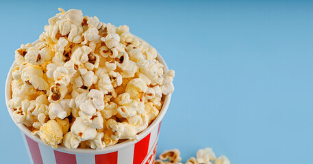 Classic red striped popcorn cardboard cup on blue background