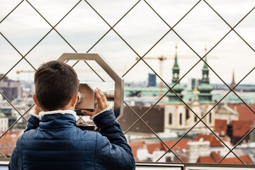A boy watches the view through a Tower Viewer from the roof of a building in Vienna, Austria.