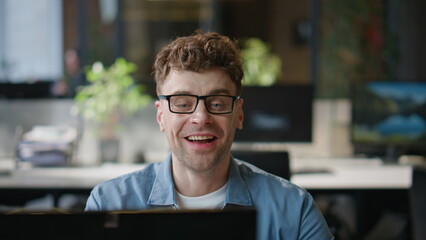 Obraz premium Creative manager calling video chat in modern office closeup. Man talking online