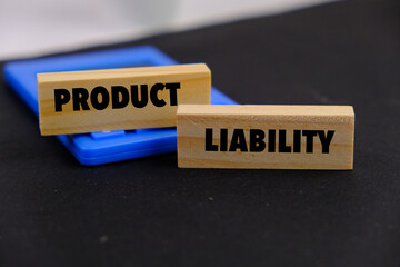 Product liability message written on wooden blocks with black background. Conceptual product...