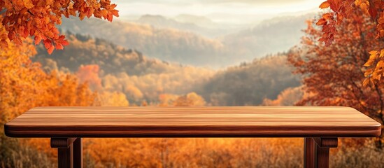 Fototapeta premium Wooden table centered in the foreground with vibrant orange and red autumn foliage and soft mountain backdrop creating a warm seasonal atmosphere