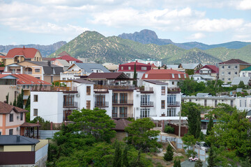 Modern residential buildings against the backdrop of mountains. A resort town. Sudak, Crimea