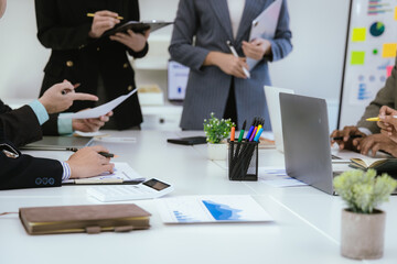 A team of professionals work together in an office to analyze financial charts, market strategies and work as a team to drive business growth and success.