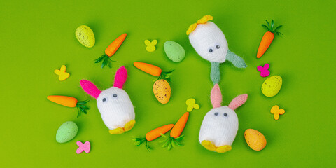 Handmade Easter concept. Knitted bunnies with traditional decoration. Festive symbols, greeting card