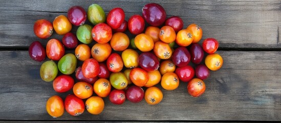 Colorful jujubes in red, orange, and green hues scattered organically on a rustic wooden surface captured from an overhead viewpoint.