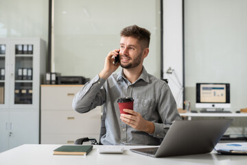 Fototapeta premium Male businessman talk mobile phones update tasks with milestones progress planning while working on laptop computers.